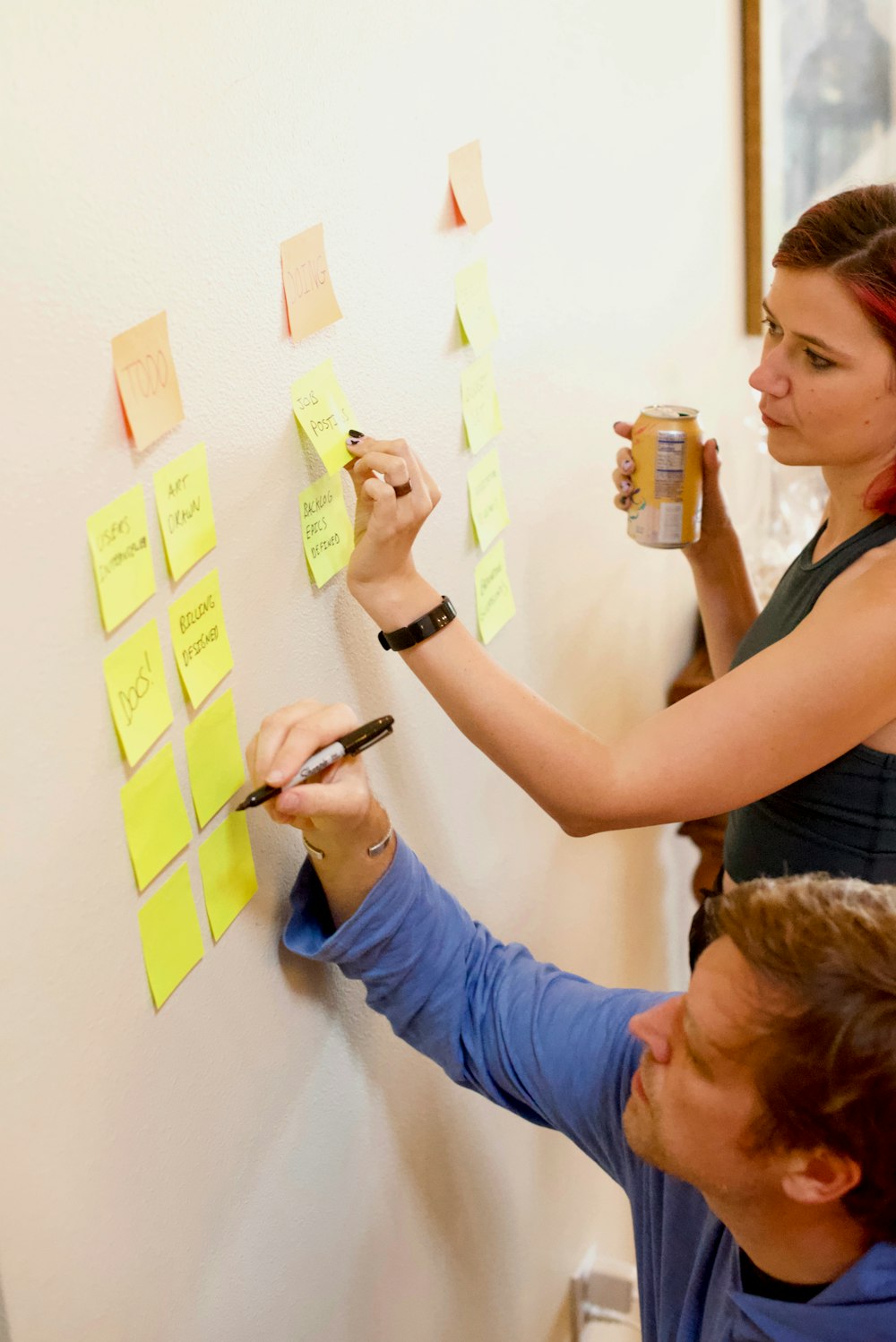 woman in blue long sleeve shirt holding yellow sticky notes