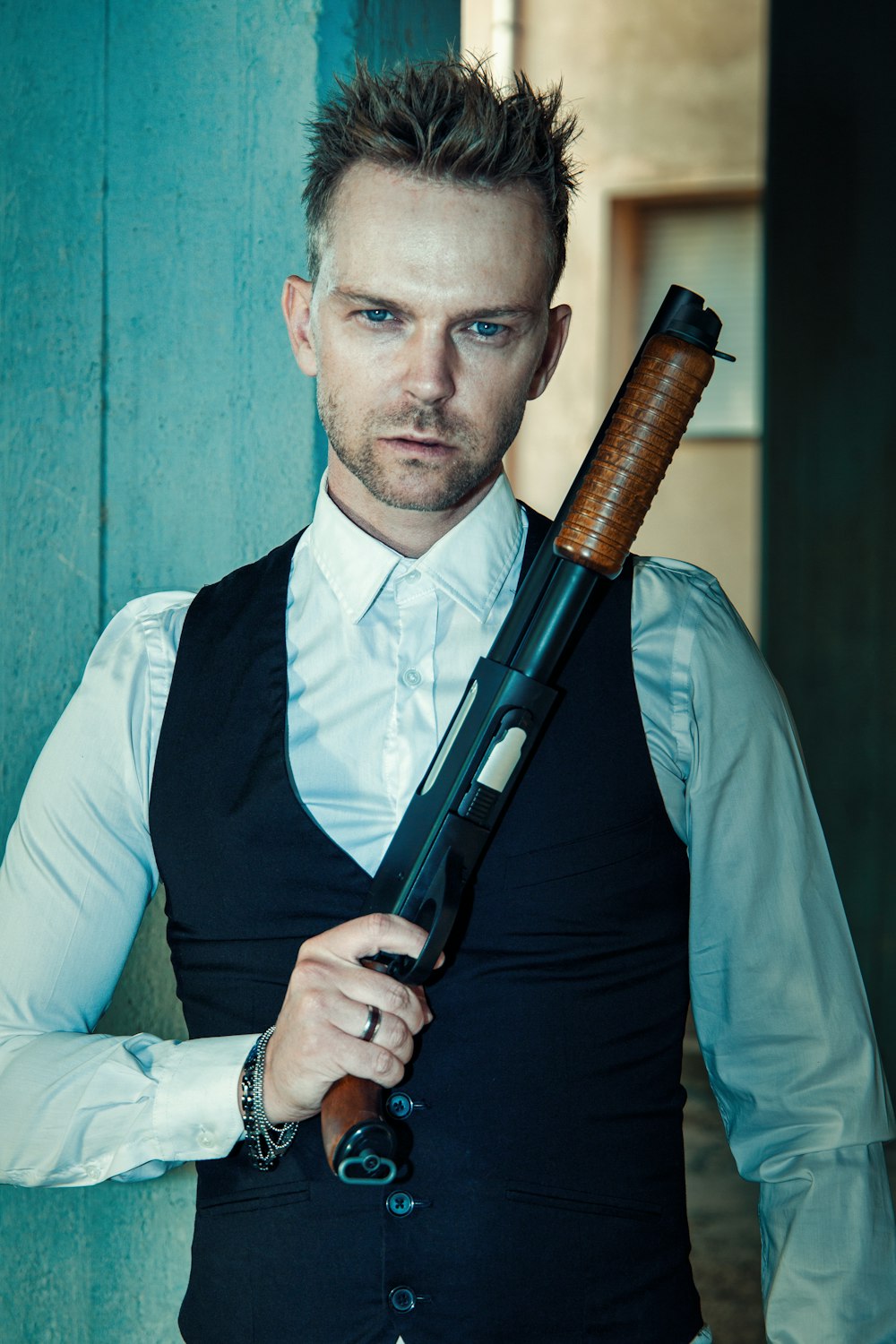 man in black vest holding black rifle