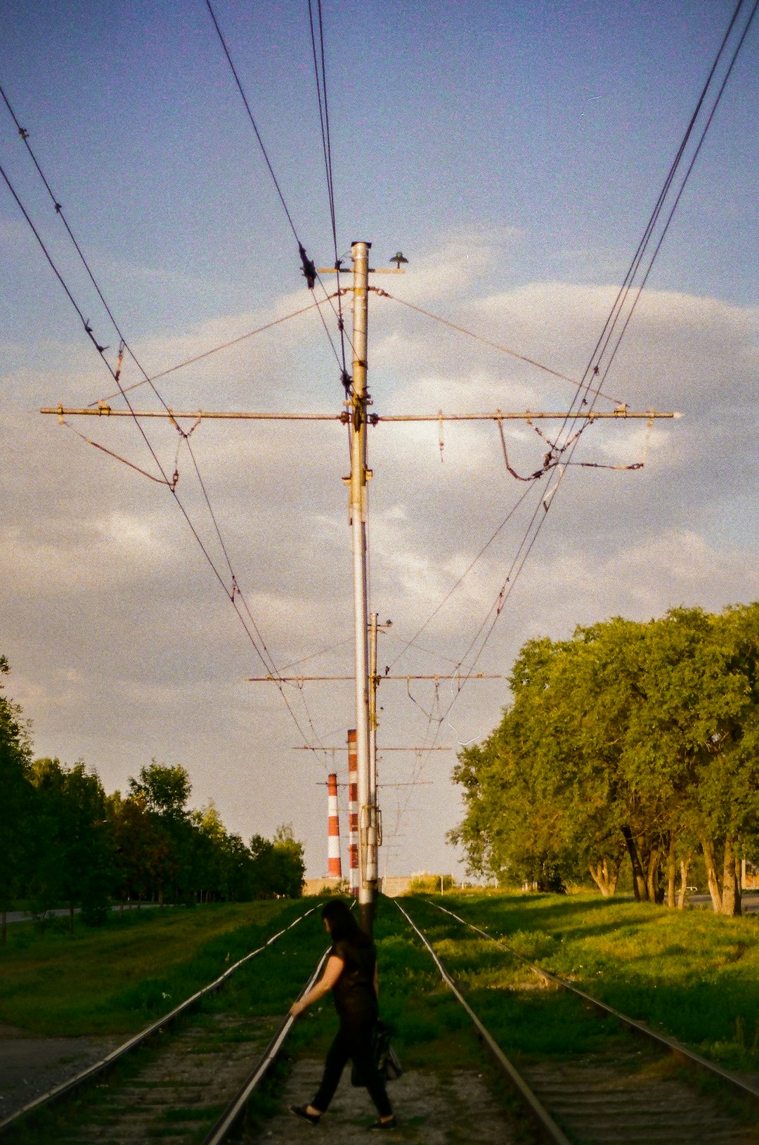 brown electric post on green grass field during daytime