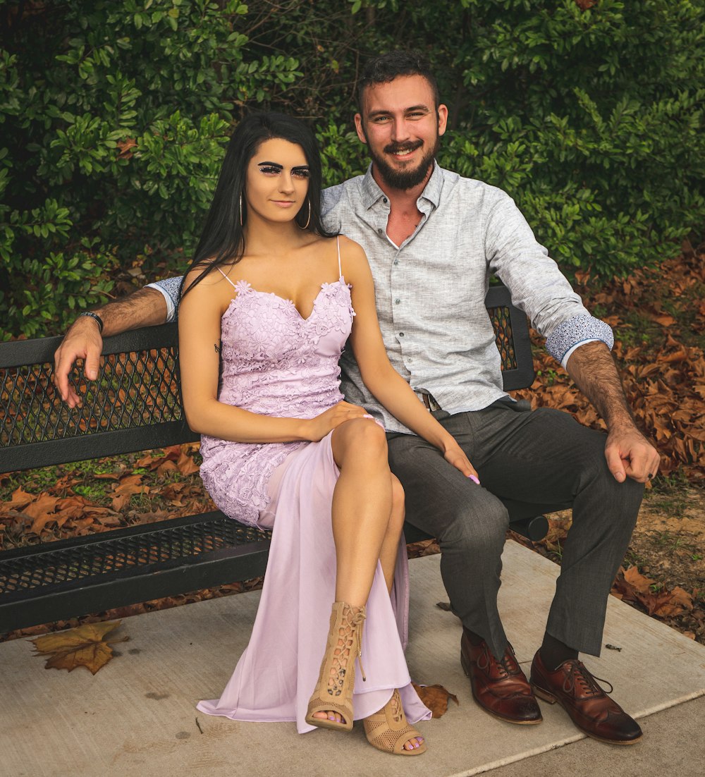 man and woman sitting on brown wooden bench