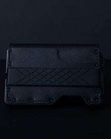 Minimalist black leather wallet engraved with a subtle geometric design.