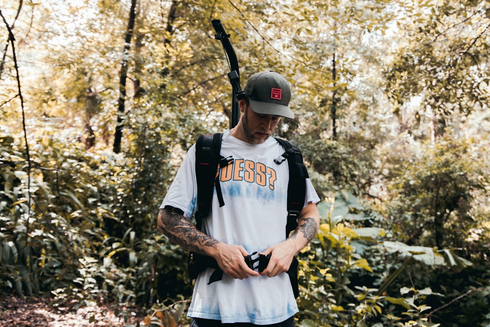 homem na camisa branca usando capacete preto e mochila preta