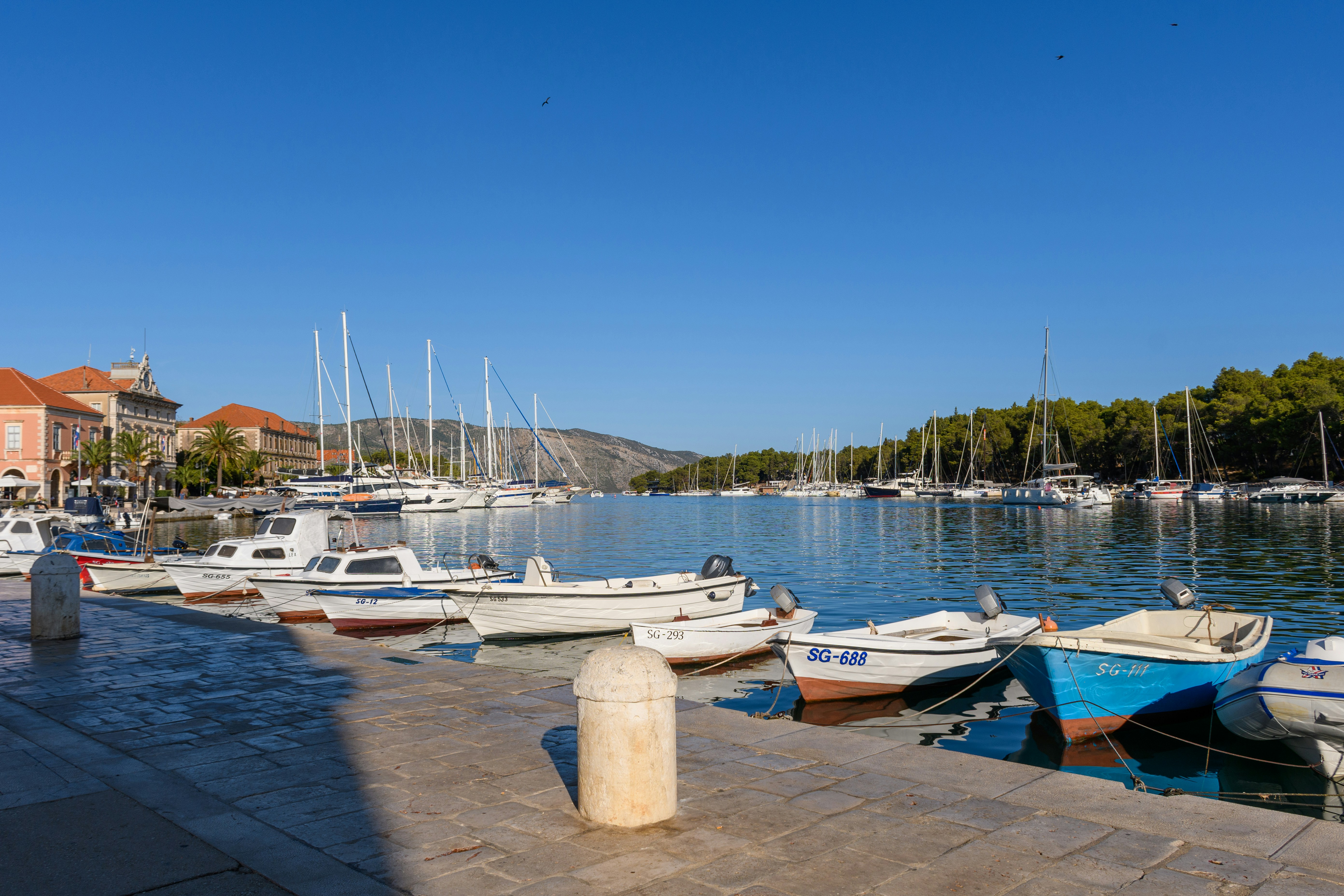 White and blue boats on dock during daytime