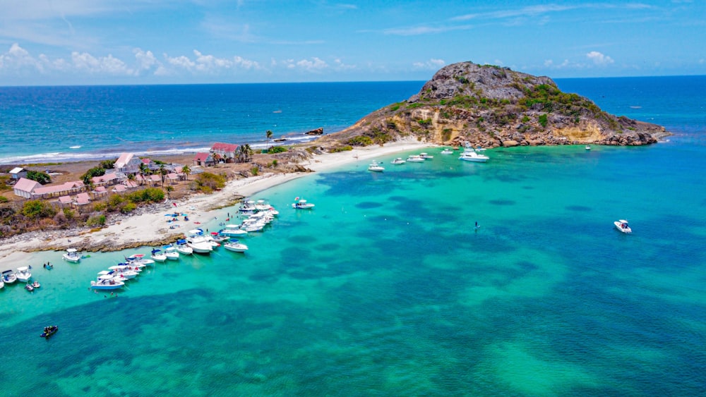 aerial view of boats on sea near island during daytime