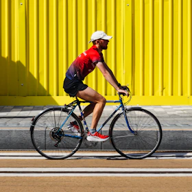 man in red shirt riding bicycle during daytime