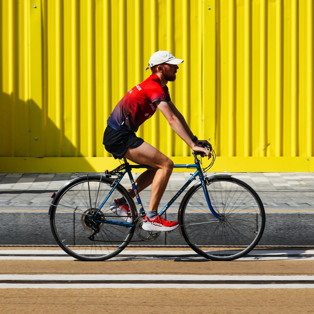 man in red shirt riding bicycle during daytime