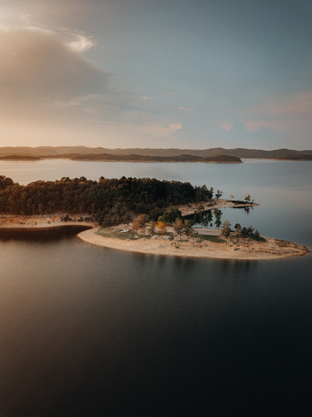 Grüne Bäume auf der Insel, tagsüber von Wasser unter weißen Wolken umgeben