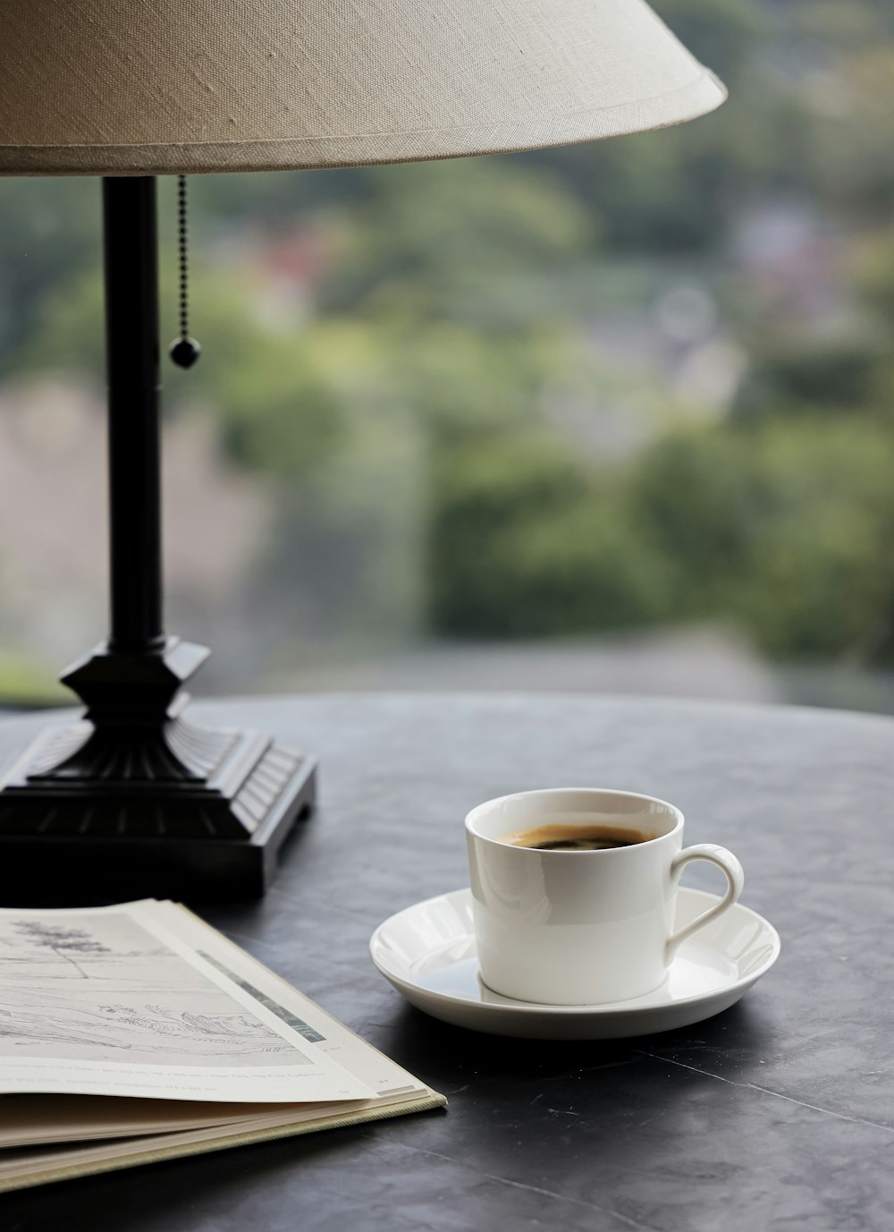 Tasse en céramique blanche sur soucoupe en céramique blanche sur table en bois brun