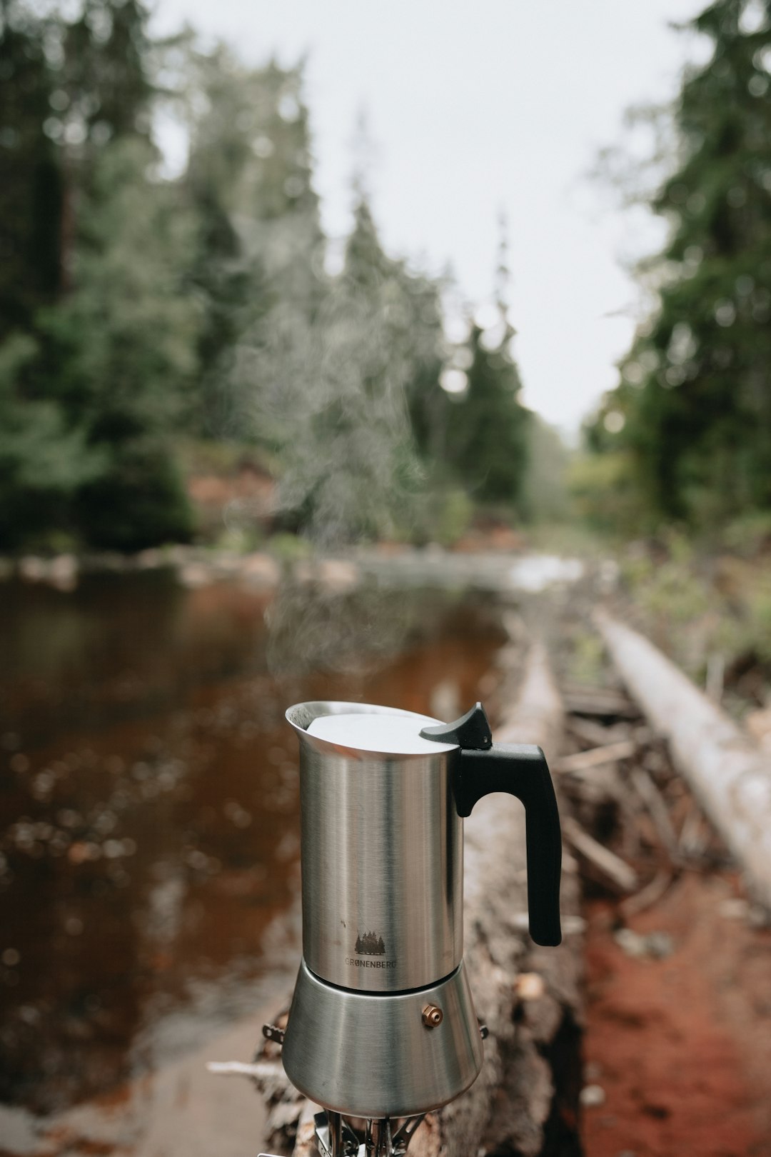 stainless steel pitcher on brown wooden table