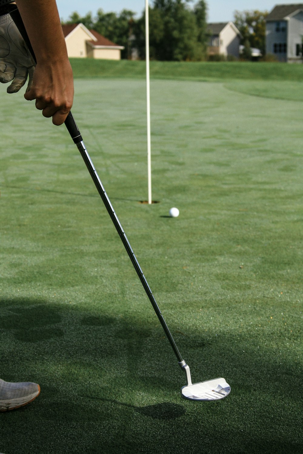 person holding golf club and golf ball