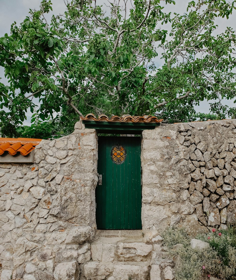 green wooden door on gray concrete wall