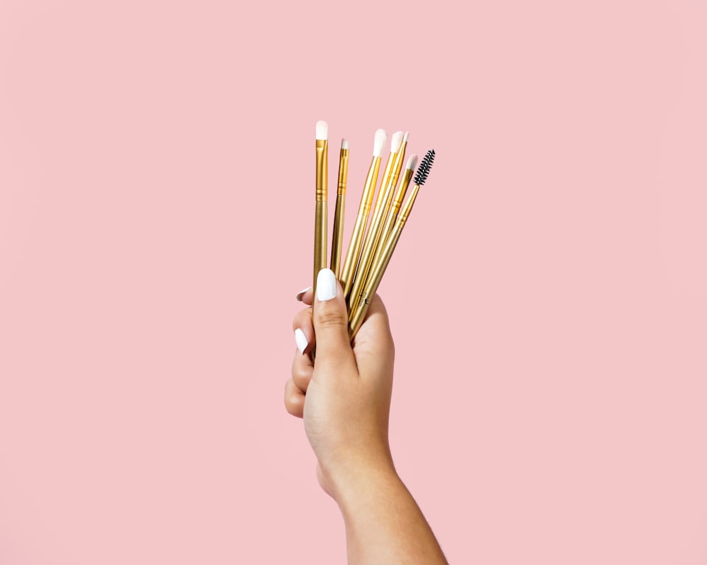 person holding brown wooden sticks