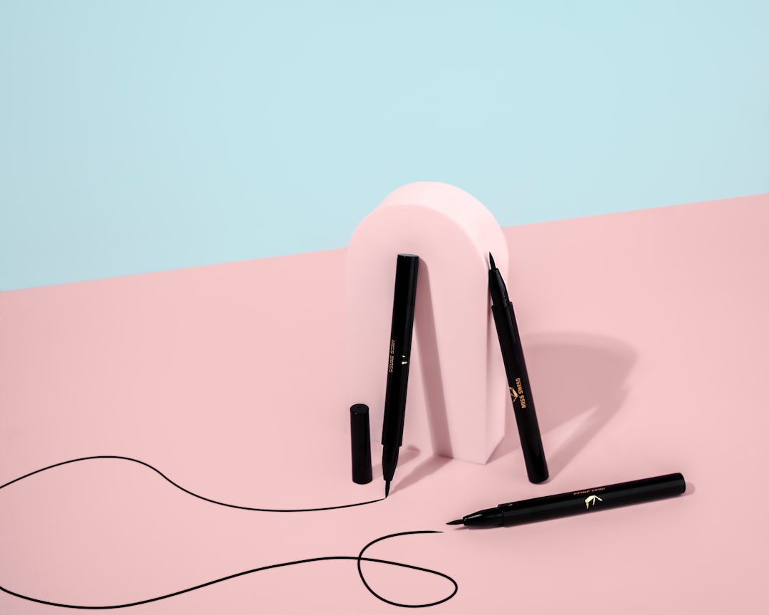 black and white wireless headphones on white table, MISS SWISS liquid eyeliner product photo