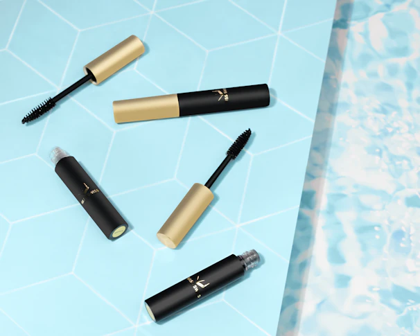 Elegant mascaras and eyeliners displayed with delicate floral accents