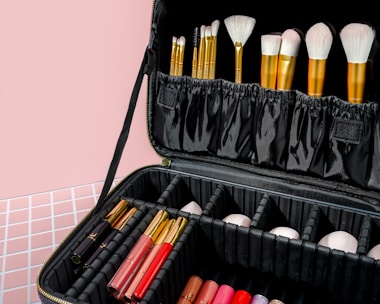 Vibrant makeup brushes and colorful palettes artistically displayed on a sleek black surface.