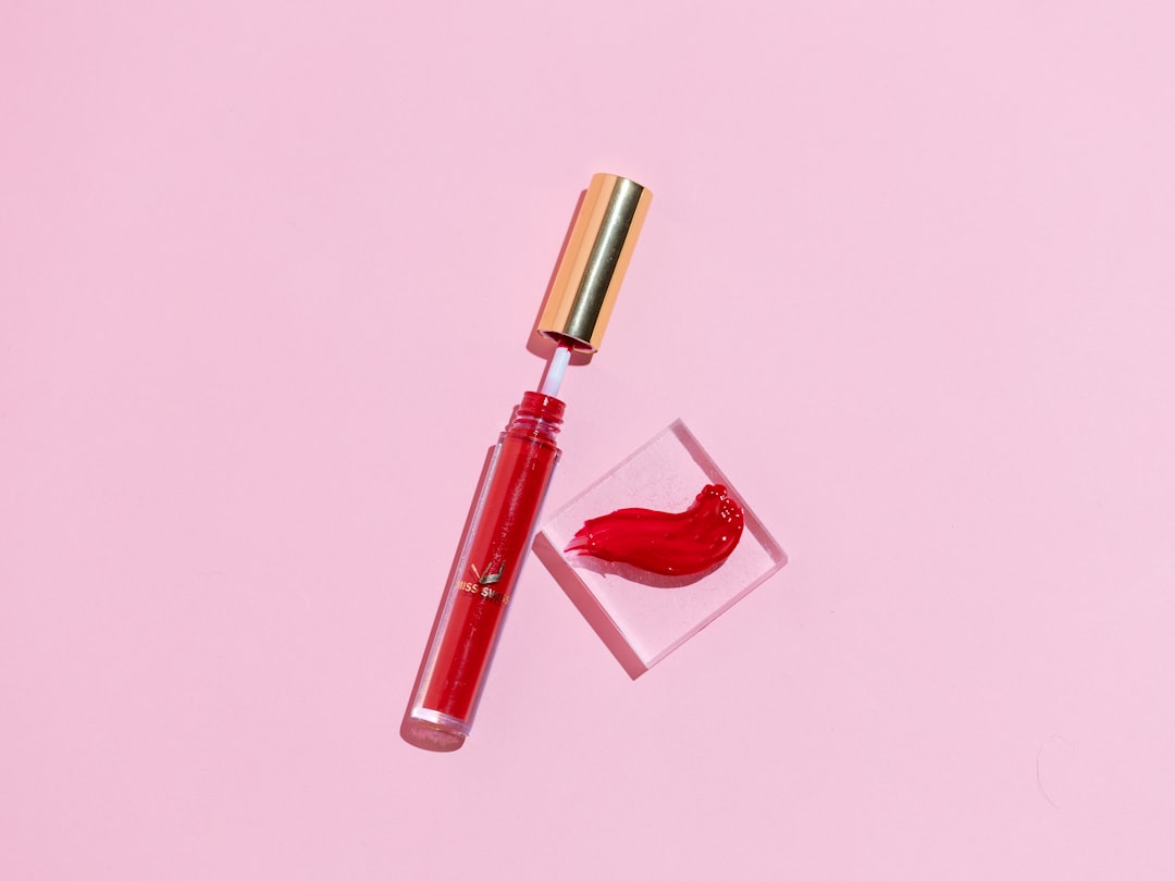 red and silver bottle with red heart print, MISS SWISS Chloe Lip Gloss Swatch and product photo