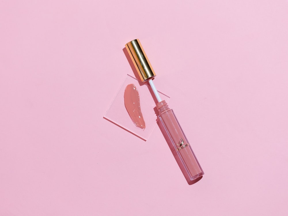 lápiz labial rosa sobre superficie rosa