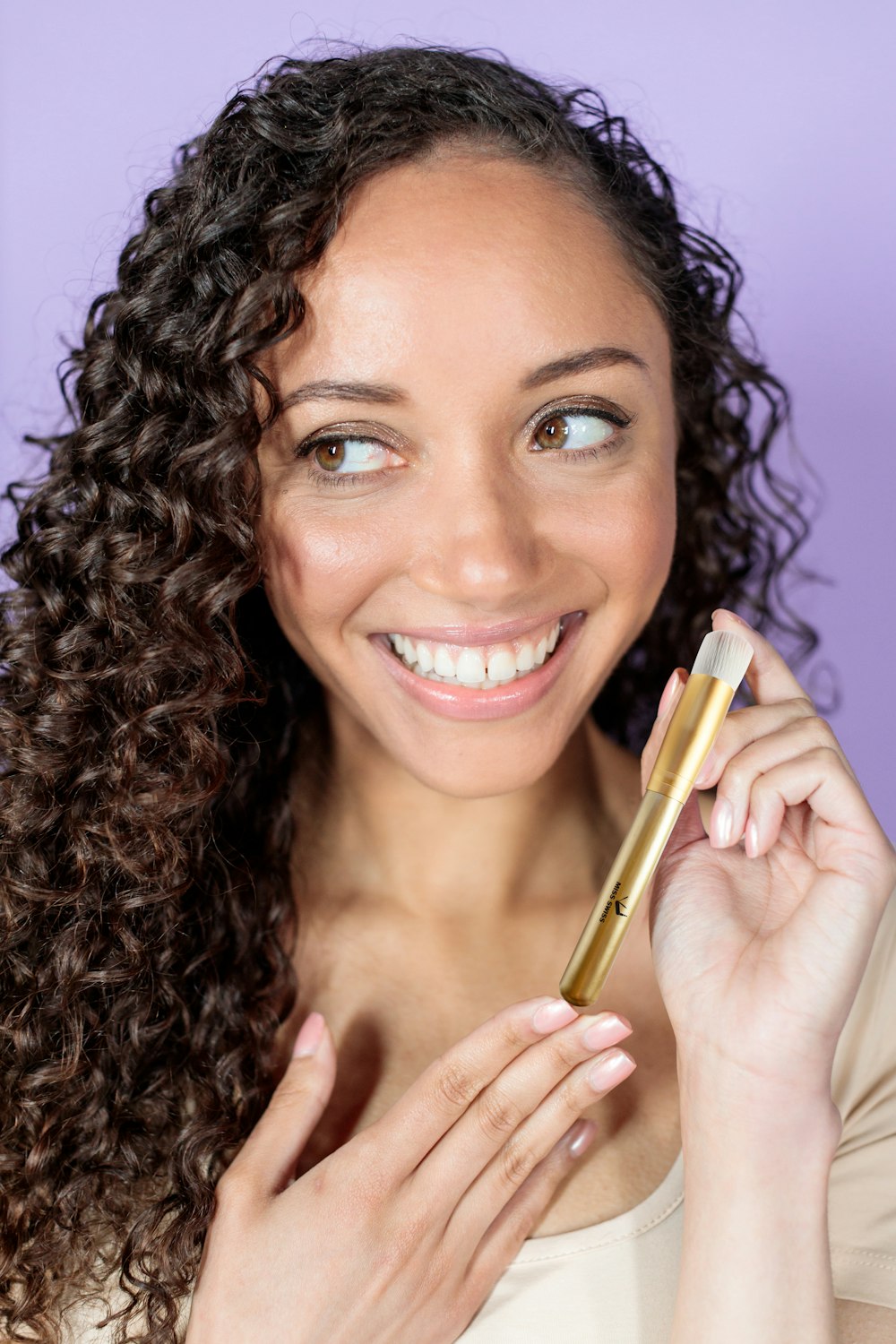 woman holding gold pen smiling