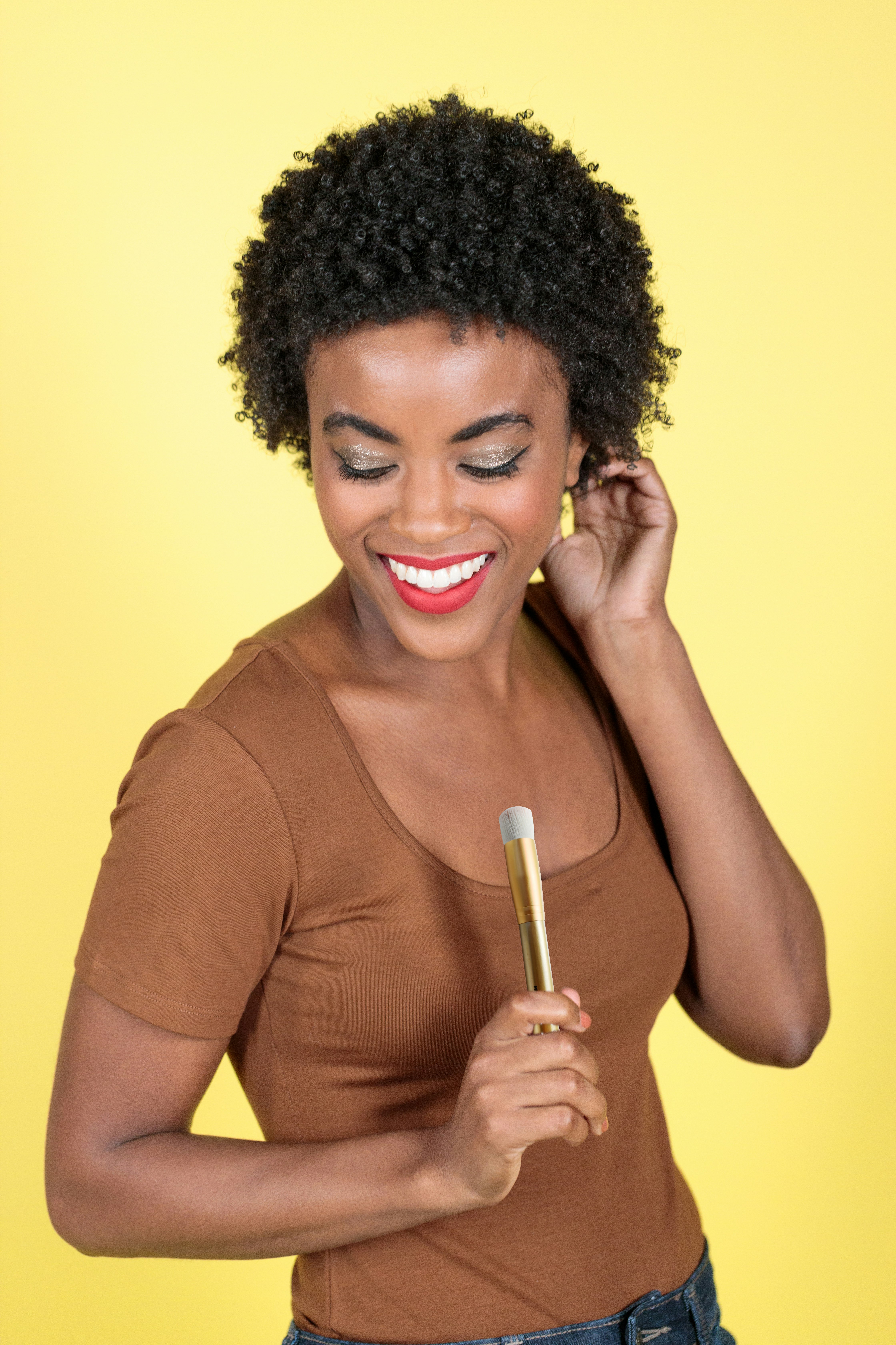 smiling woman in brown long sleeve shirt holding white cigarette stick