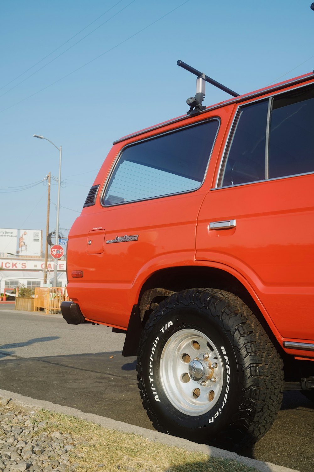 日中の灰色のアスファルト道路を走る赤いSUV