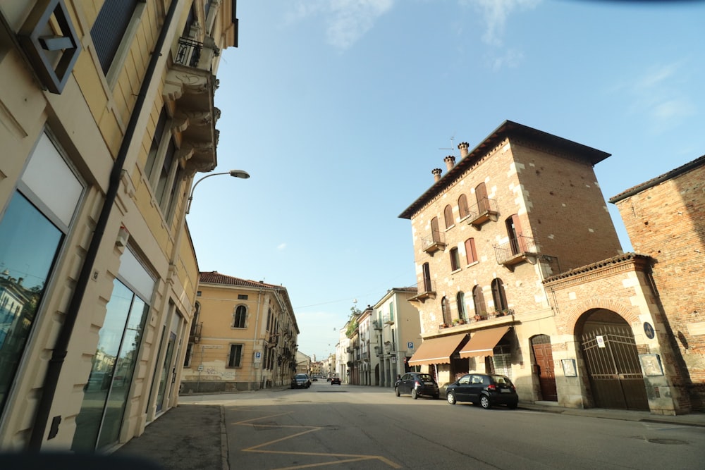 cars parked on side of the road near buildings during daytime