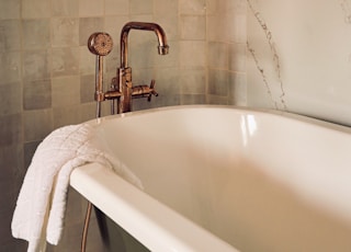 white ceramic bathtub with stainless steel shower head