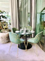 Modern outdoor dining table with sleek chairs surrounded by lush greenery