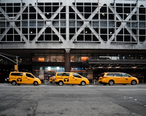 yellow taxi cab on road near white building