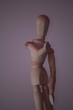 brown wooden human figure on white surface