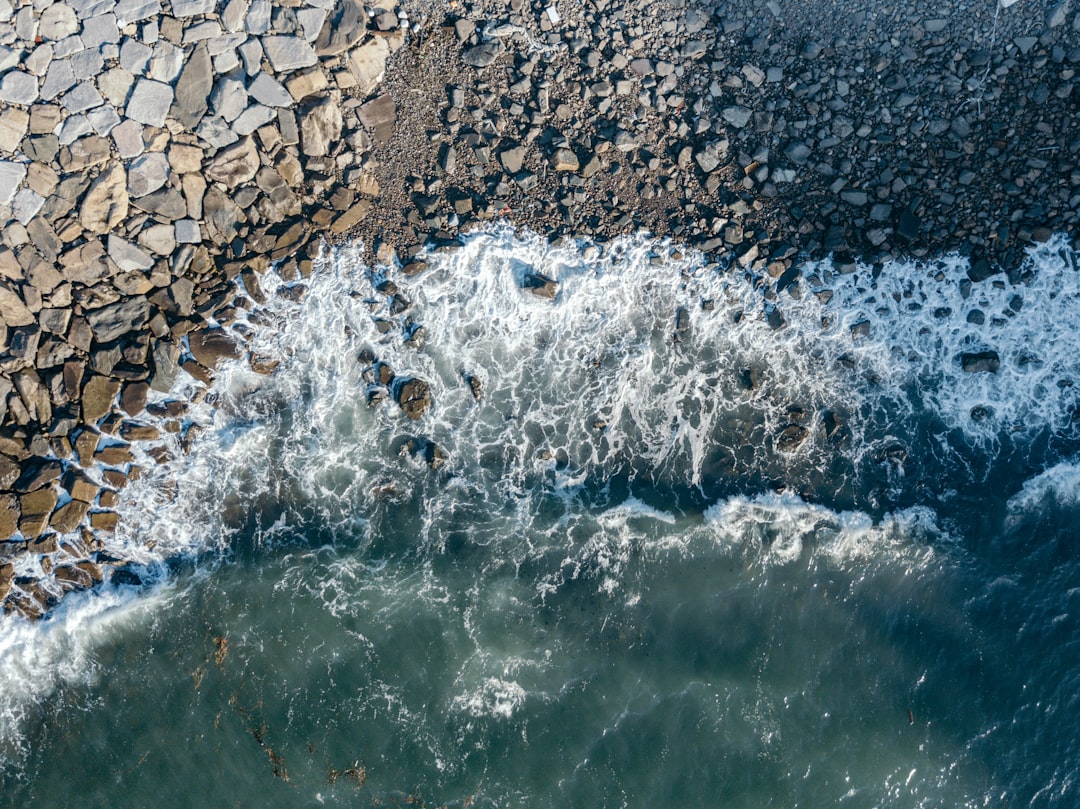 water waves hitting rocks during daytime