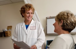 woman in white scrub suit holding gray laptop computer