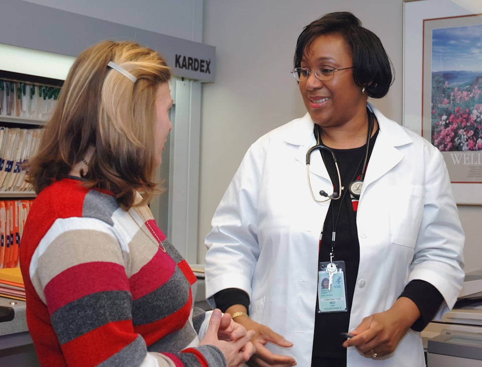 A healthcare provider having a compassionate, unhurried conversation with a senior patient in her home.