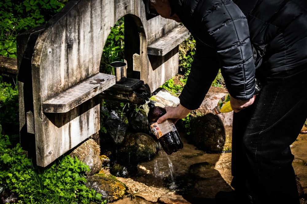 a person pouring water into a small stream