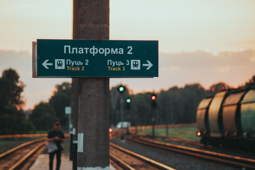 a couple of people standing next to a train track