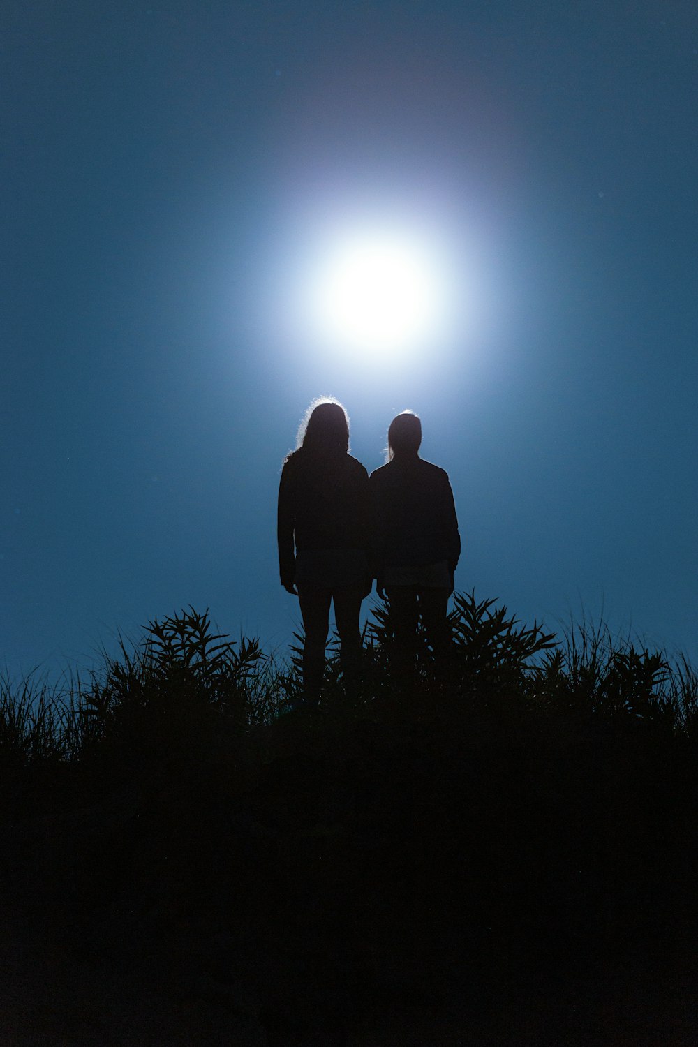 silhouette of man standing on grass field during daytime