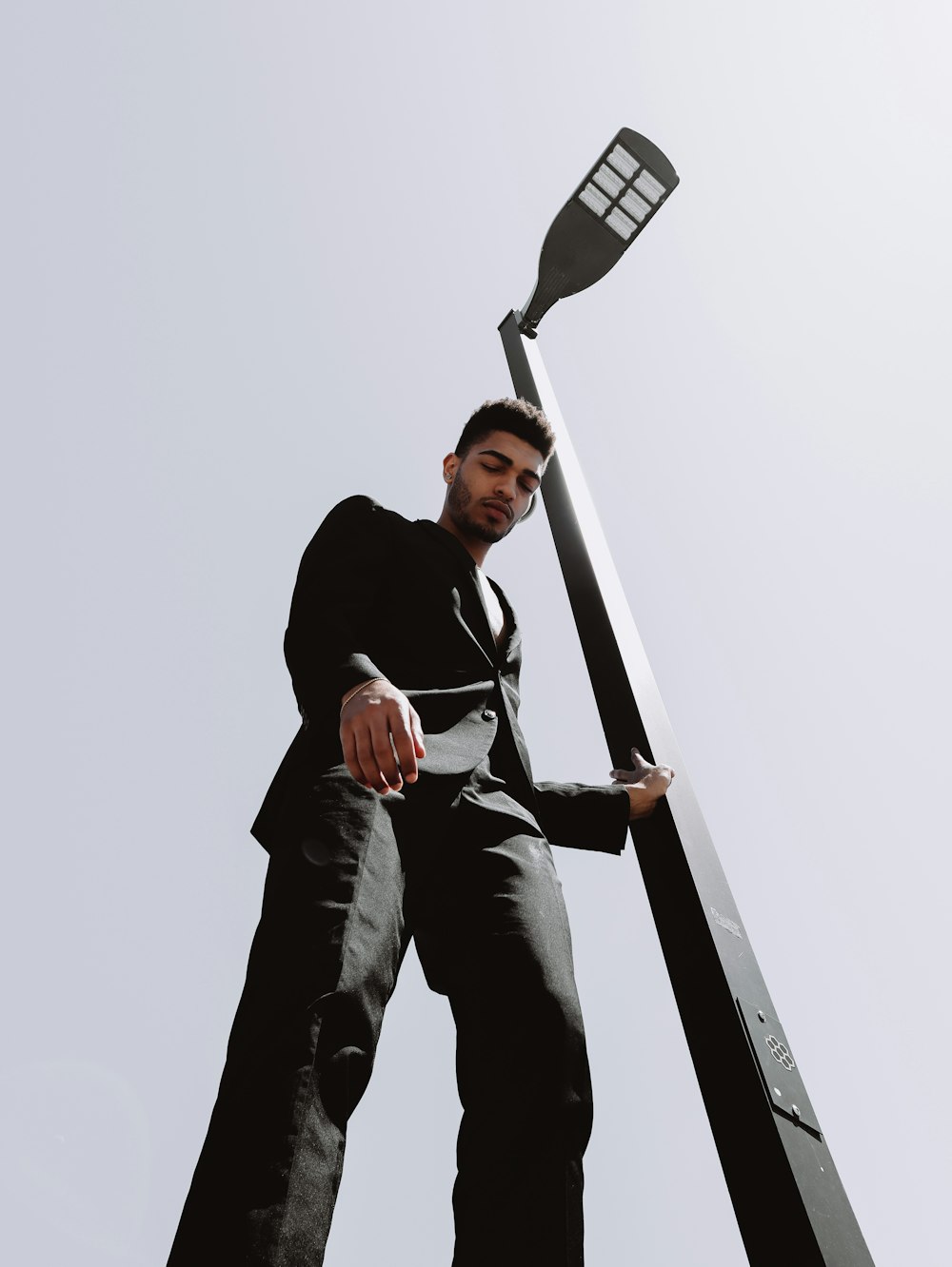 man in black jacket and blue denim jeans sitting on black skateboard