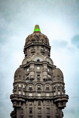 white and brown concrete building under white clouds during daytime