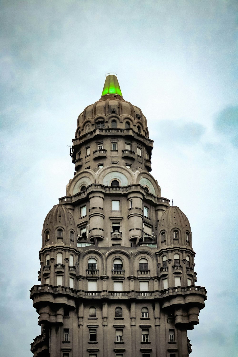 edifício de concreto branco e marrom sob nuvens brancas durante o dia