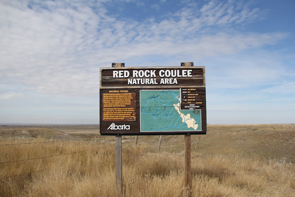 a sign in the middle of a dry grass field