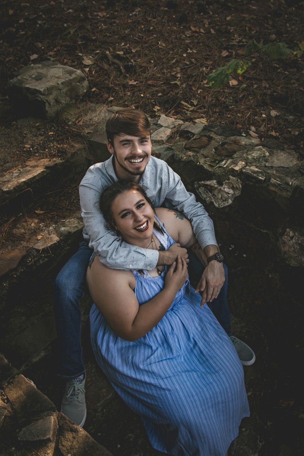 man in blue dress shirt hugging woman in white long sleeve shirt