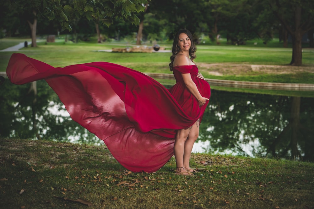 낮 동안 푸른 잔디밭에 앉아 빨간 드레스를 입은 여자