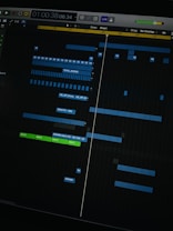 A digital audio workstation interface displaying a timeline with various tracks. Blue and green colored bars represent different audio elements, indicating a complex music project in progress. The interface includes time markers, labels, and controls for editing sound files.