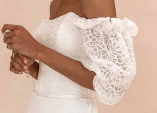 woman in white lace dress holding white bouquet