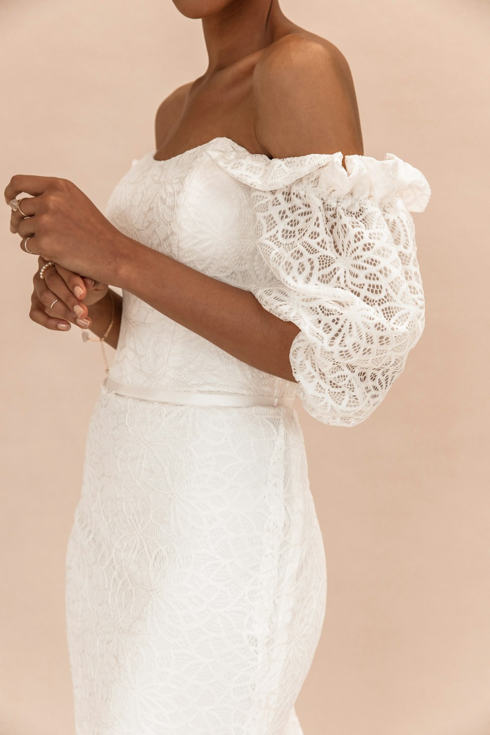 woman in white lace dress holding white bouquet