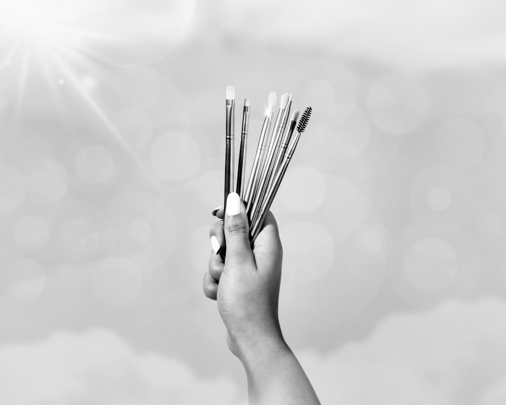 grayscale photo of person holding sticks