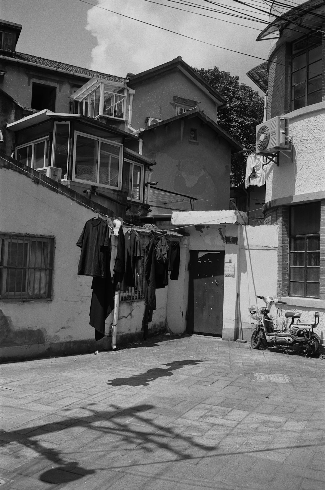 grayscale photo of clothes hanged on wire