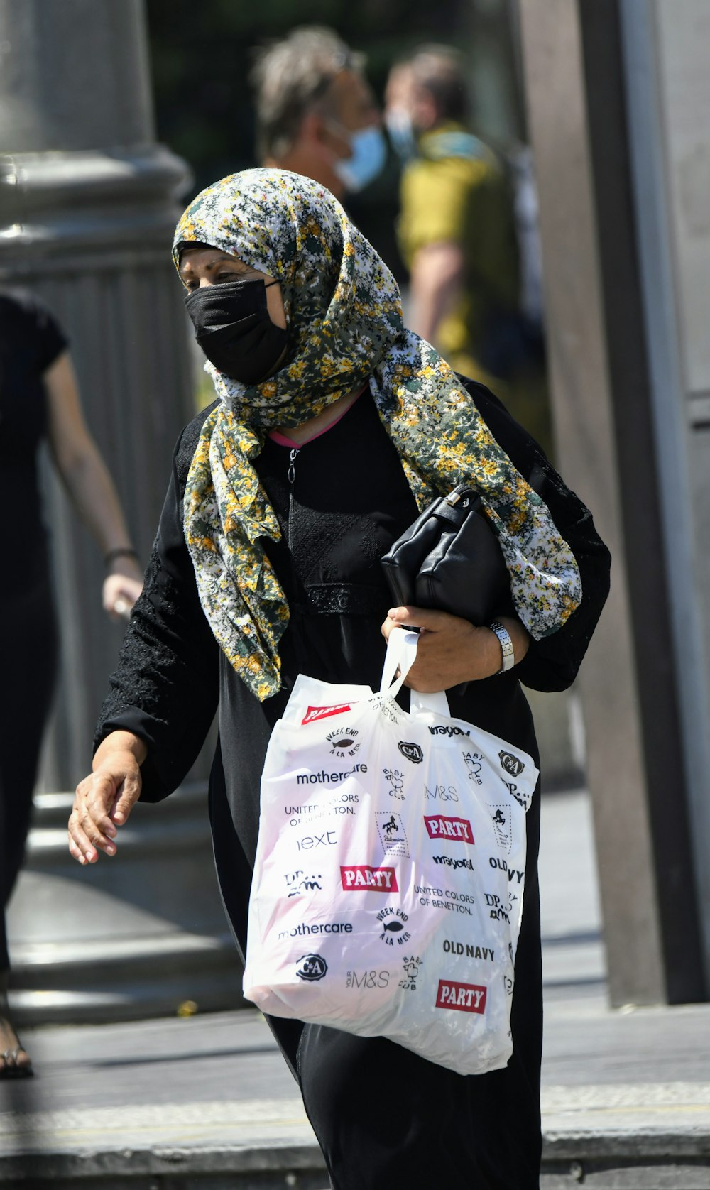 donna in camicia a maniche lunghe nera e marrone che tiene il sacchetto di plastica bianco