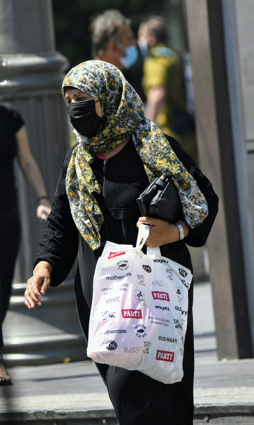 woman in black and brown long sleeve shirt holding white plastic bag