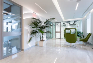 A modern office space with crisp white desks and clear glass partitions, showcasing Tootsie’s commercial cleaning excellence.