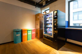 black and blue vending machine beside brown wooden cabinet